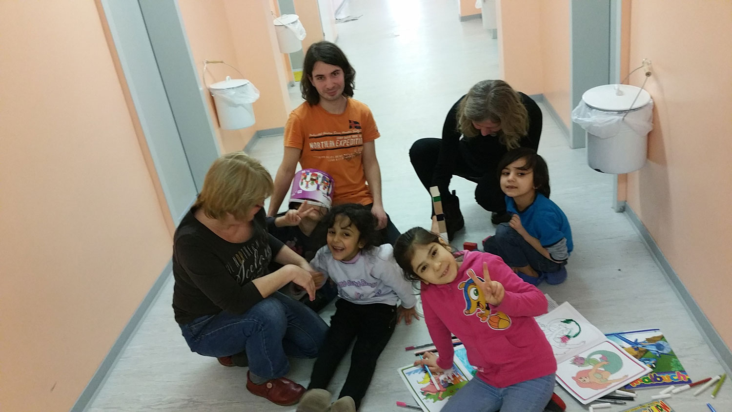 Helfer der Initiative WOLV spielen mit Flüchtlingskindern auf dem Flur im 2. Obergeschoss in der Unterkunft am Leegebrucher Kreisel